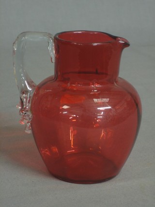 A cranberry glass jug with clear glass handle 4 1/2"