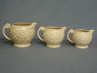 A set of 3 graduated Arthur Wood brown glazed pottery jugs with floral decoration (slight chip to middle jug spout) 6"