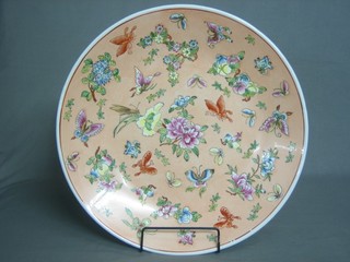 A circular Oriental peach glazed and floral patterned charger, decorated butterflies 17 1/2"