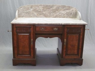 A Victorian walnut wash stand with grey veined marble top and three-quarter gallery, the base fitted a drawer flanked by a pair of cupboards 48"