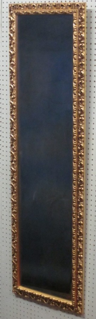 A rectangular bevelled plate wall mirror contained in a decorative gilt frame 48" x 14"