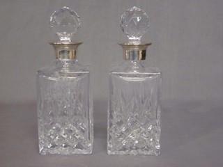 A pair of modern cut glass spirit decanters and stoppers with silver collars