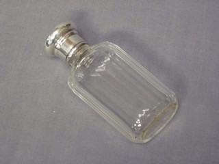 A glass scent bottle with silver lid