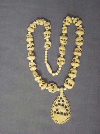 A carved ivory pendant decorated an elephant hung on a string of carved beads