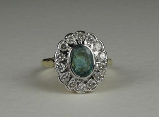 An 18ct yellow gold dress ring set an oval cut emerald surrounded by diamonds