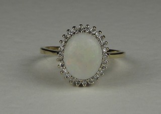 A 9ct yellow gold dress ring set an oval cut opal surrounded by diamonds