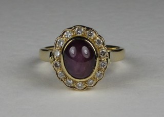 An 18ct yellow gold dress ring set a cabouchon cut ruby surrounded by diamonds