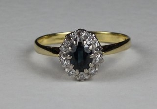A gold dress ring set an oval "sapphire" surrounded by diamonds