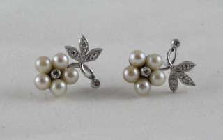 A pair of floral shaped earrings set pearls and diamonds