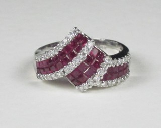 An 18ct white gold dress ring set square cut rubies supported by diamonds