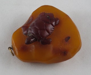 A carved amber pendant decorated a turtle