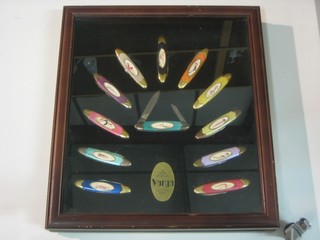 12 Varga Girl folding pocket knives contained in a display cabinet