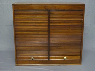 A Victorian mahogany cabinet enclosed by tambour shutters, raised on a platform base 36"