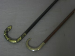 A walking cane with white metal handle and 1 other