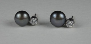 A pair of 18ct white gold drop ear studs, each set a diamond and a black pearl