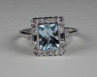 An 18ct white gold dress ring set a square cut aquamarine surrounded by diamonds