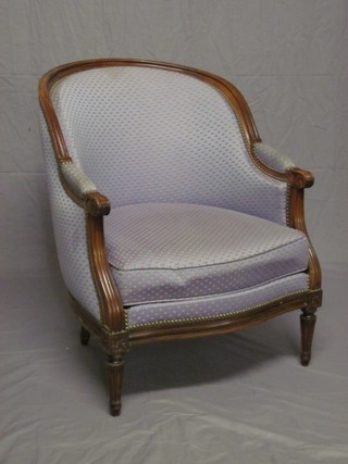 A pair of mahogany show frame tub back chairs upholstered in blue material and raised on turned and fluted supports