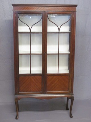 An Edwardian inlaid mahogany display cabinet, the interior fitted adjustable shelves enclosed by astragal glazed doors, the base fitted an undertier, raised on square tapering supports ending in spade feet 29" ILLUSTRATED
