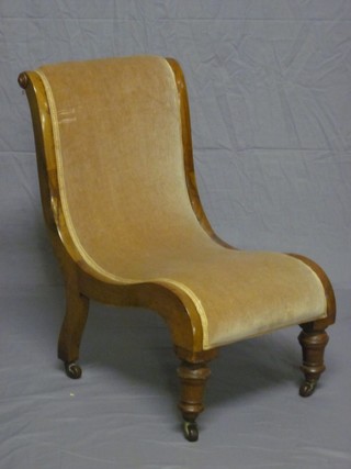 A Victorian walnut show frame nursing chair upholstered in mushroom coloured material, raised on turned supports