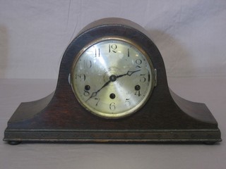 A 1930's chiming mantel clock with silvered dial and Arabic numerals, contained in an oak Admiral's hat shaped case