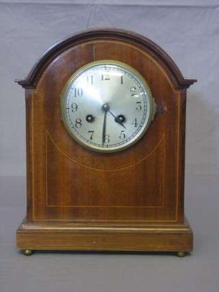 An Edwardian French 8 day striking mantel clock with silvered dial and Arabic numerals contained in a mahogany arch shaped case
