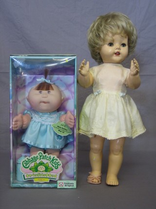 A Cabbage Patch Kid doll together with a plastic walking doll