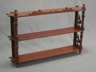 An Edwardian mahogany 2 tier hanging shelf, raised on turned supports 32"