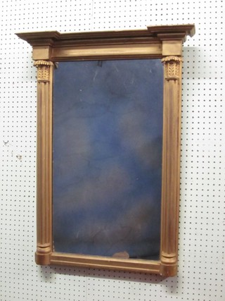 A rectangular plate mirror contained in a decorative gilt frame supported by 2 reeded columns 33"