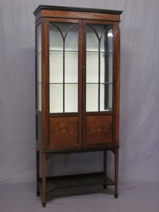 An Edwardian mahogany display cabinet, the interior fitted shelves enclosed by astragal glazed panelled doors, raised on cabriole supports 36"