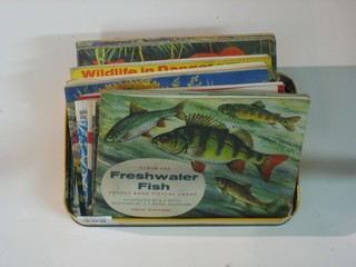 A tin containing a collection of tea card albums