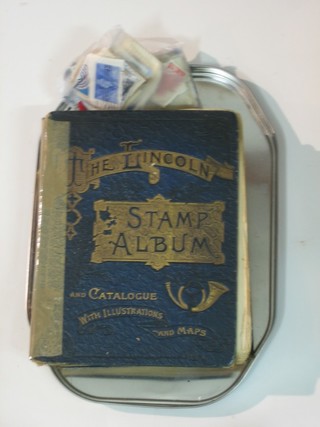 A blue Lincoln stamp album and a collection of loose stamps
