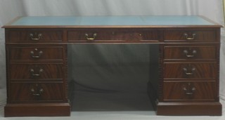 A Georgian style mahogany kneehole pedestal partners desk with inset blue leather writing surface, the frieze fitted 2 long and 2 short drawers, the pedestals with canted corners fitted 6 long drawers and cupboards 72"