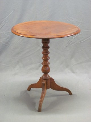 A circular Victorian walnut wine table raised on a turned column and tripod base 23"