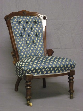 A Victorian walnut show frame nursing chair upholstered in blue buttoned material and raised on turned and fluted supports