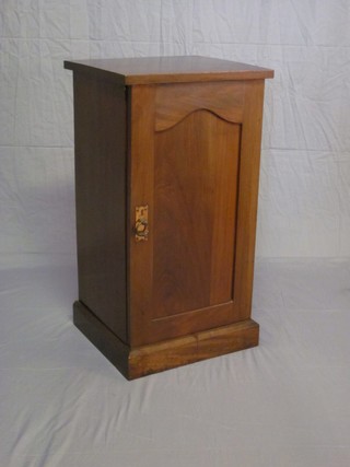 A Victorian walnut pot cupboard enclosed by an arch shaped panelled door, raised on a platform base 16"