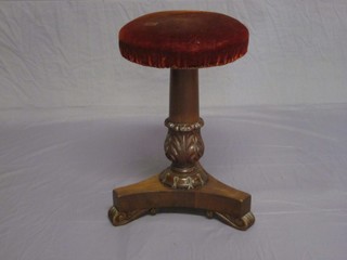 A William IV Mahogany revolving adjustable piano stool, raised on a turned column with triform base