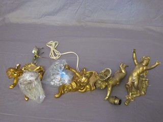 A pair of gilt plaster wall light brackets in the form of cherubs holding lustres and a gilt metal light fitting in the form of a flying cherub and 1 other in the form of a cherub