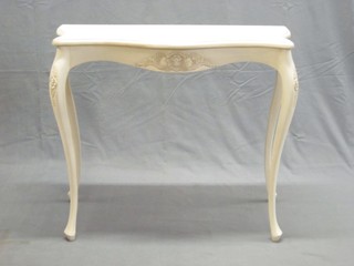 A French style whited painted side table of serpentine outline, raised on cabriole supports 35"
