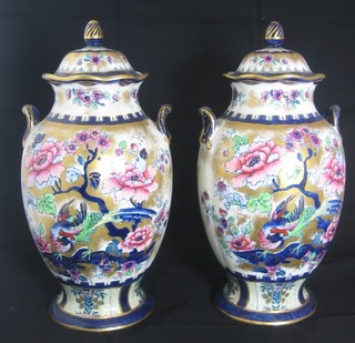 A pair of Losolware pottery twin handled urns and covers with floral decoration 12"