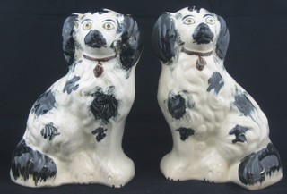 A pair of Staffordshire style figures of seated black and white Spaniels 8"