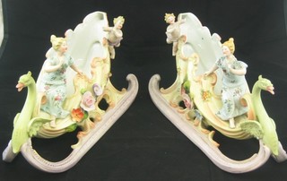 A pair of 19th Century Continental porcelain boat shaped vases in the form of sleighs decorated standing ladies and cherubs (some chips to fingers) 9"