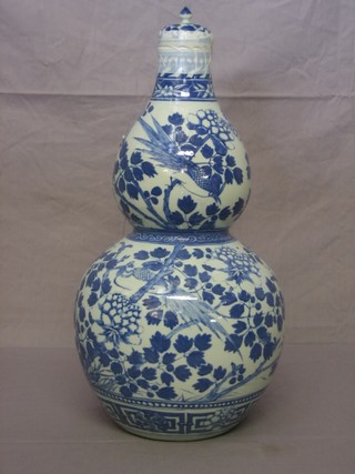 An Oriental blue and white double gourd shaped vase and cover 18"
