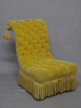 An Edwardian ebonised nursing chair upholstered in gold buttoned Dralon, raised on turned supports