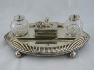 A handsome Victorian oval silver plated standish with 2 cut glass inkwells with pen recess and stamp box, the lid in the form of a seated sphinx raised on bun feet by Benetfink & Co Cheapside ILLUSTRATED