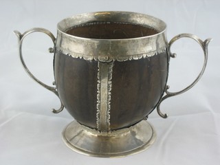 A handsome 17th Century Coconut and silver mounted twin handled cup, the spreading base with engraved armorial decoration 4", the base marked 4.5.0 ILLUSTRATED