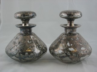 A pair of circular squat shaped decanters and stoppers with silver mounts (1 f)