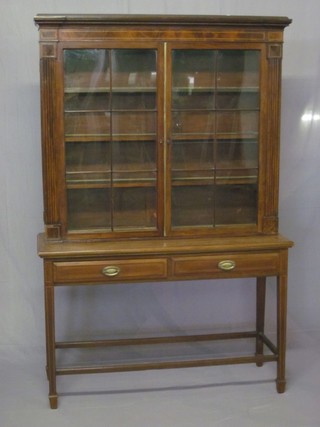 A mahogany cabinet on stand, the upper section with moulded  cornice, fitted shelves enclosed by astragal glazed panelled doors,  the base fitted 2 long drawers, raised on square tapering supports  ending in spade feet 48"