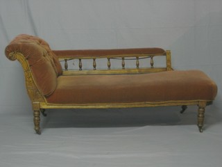 An Edwardian carved walnut show frame chaise longue  upholstered in orange material, raised on turned supports 62"