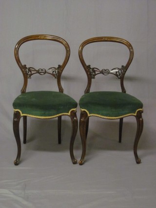 A pair of Victorian carved mahogany balloon back dining chairs  with carved mid rails and upholstered seats, raised on cabriole  supports