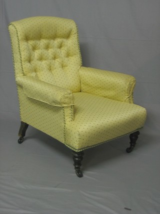 A Victorian mahogany armchair upholstered in yellow material,  raised on turned supports